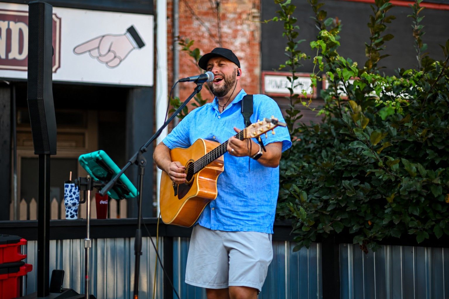 Tommy Renfro singing and playing acoustic guitar at an outdoor show